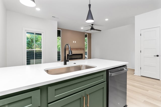 kitchen with dishwasher, sink, hanging light fixtures, green cabinetry, and ceiling fan