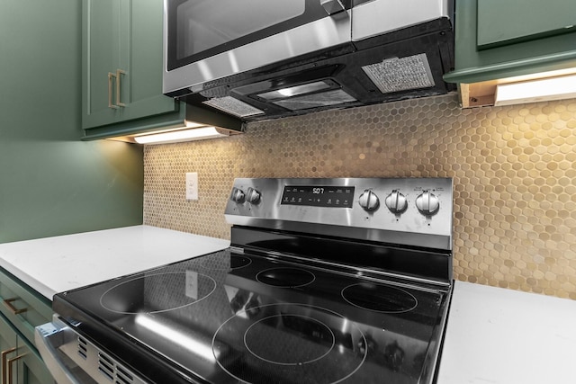 kitchen with green cabinets, stainless steel appliances, and tasteful backsplash