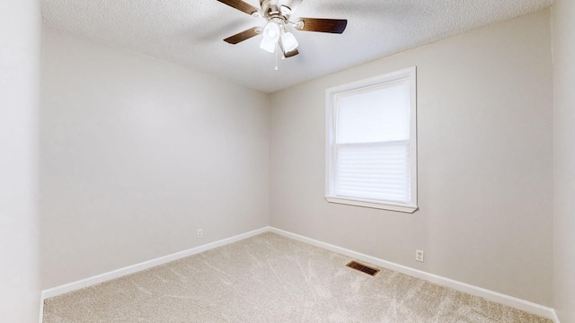 carpeted empty room featuring ceiling fan and a textured ceiling