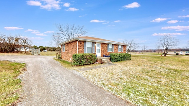 view of front of property featuring a storage shed and a front lawn