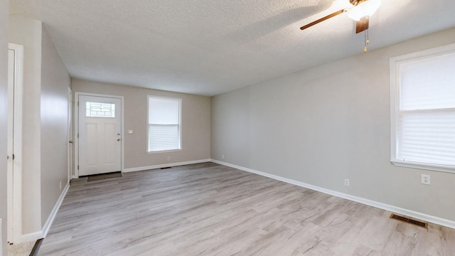 entryway featuring ceiling fan, light hardwood / wood-style flooring, and a textured ceiling