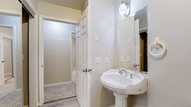 bathroom featuring wood-type flooring and a textured ceiling