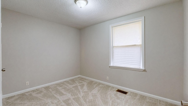 carpeted spare room featuring a textured ceiling