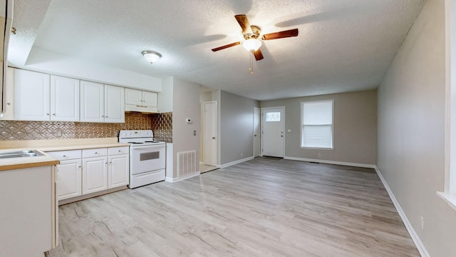 kitchen with white range with electric cooktop, decorative backsplash, light hardwood / wood-style floors, and white cabinetry