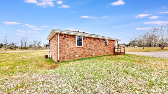 view of side of property with a lawn and central AC unit