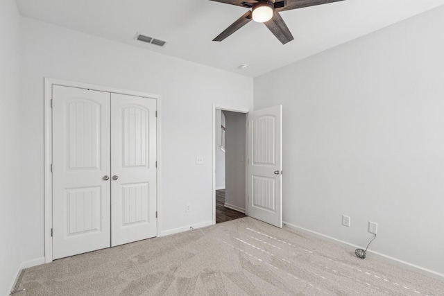 unfurnished bedroom featuring ceiling fan, light carpet, and a closet