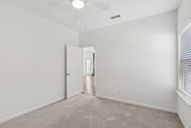 unfurnished room featuring light carpet, ceiling fan, and a healthy amount of sunlight