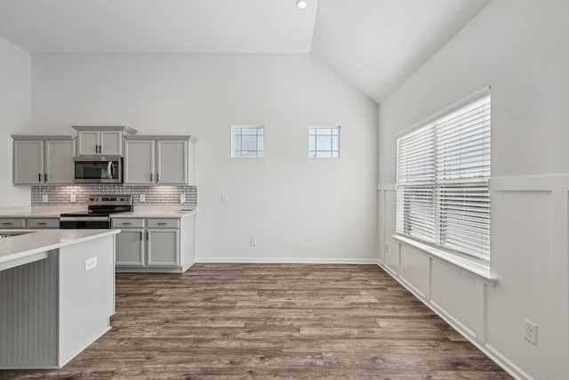 kitchen featuring decorative backsplash, appliances with stainless steel finishes, lofted ceiling, and gray cabinetry