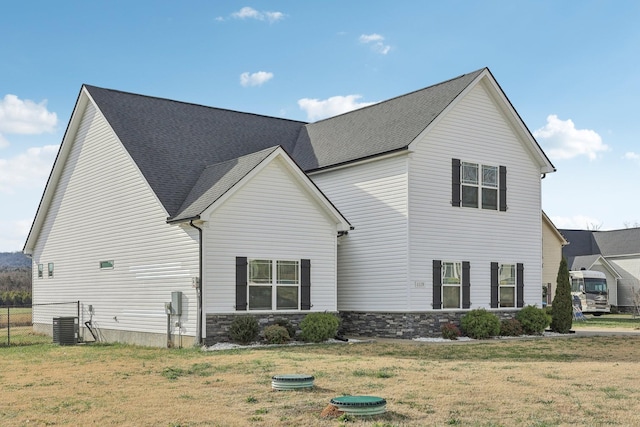 exterior space with central air condition unit and a yard