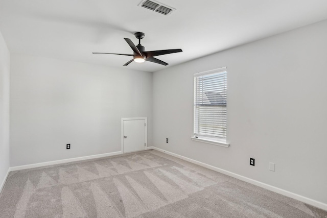 empty room featuring ceiling fan and light colored carpet