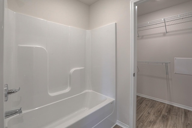 bathroom with wood-type flooring and shower / washtub combination