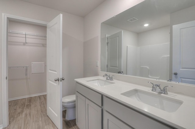 bathroom featuring vanity, wood-type flooring, and toilet