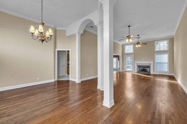 unfurnished living room featuring ornate columns, a high ceiling, crown molding, a fireplace, and ceiling fan with notable chandelier