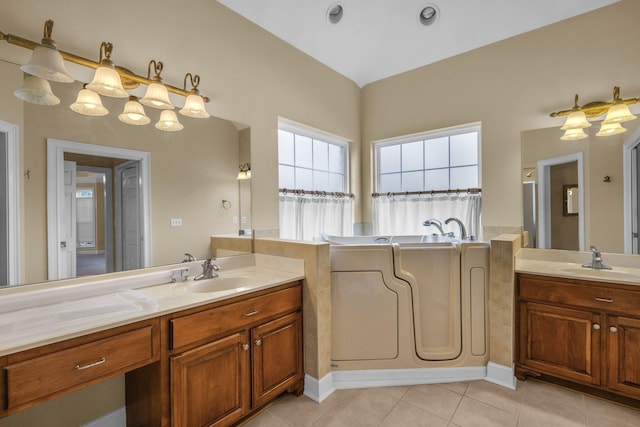 bathroom featuring tile patterned floors, a tub, and vanity