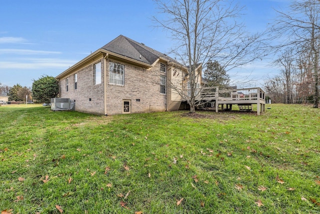 view of side of property with a lawn, central air condition unit, and a wooden deck