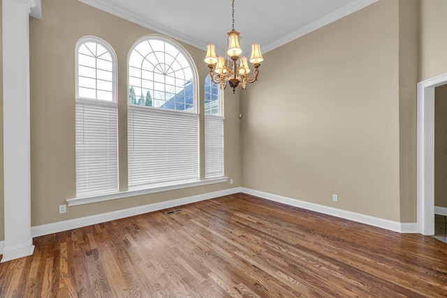 unfurnished dining area with hardwood / wood-style flooring, a notable chandelier, and ornamental molding