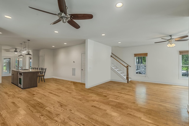 unfurnished living room with sink and light wood-type flooring