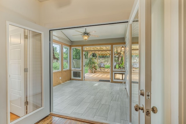 doorway to outside featuring ceiling fan, vaulted ceiling, and light hardwood / wood-style flooring