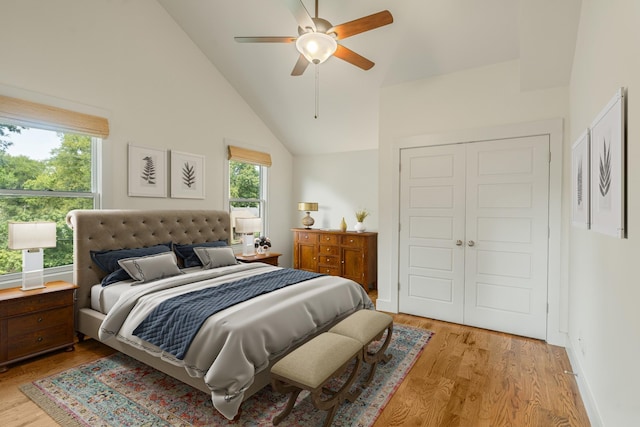 bedroom featuring a closet, ceiling fan, light hardwood / wood-style flooring, and high vaulted ceiling