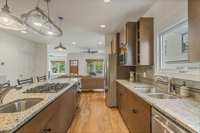 kitchen featuring pendant lighting, ceiling fan, sink, and appliances with stainless steel finishes