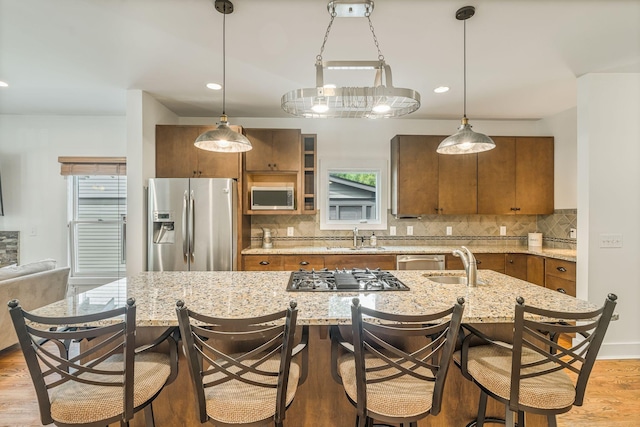 kitchen with appliances with stainless steel finishes, hanging light fixtures, and sink