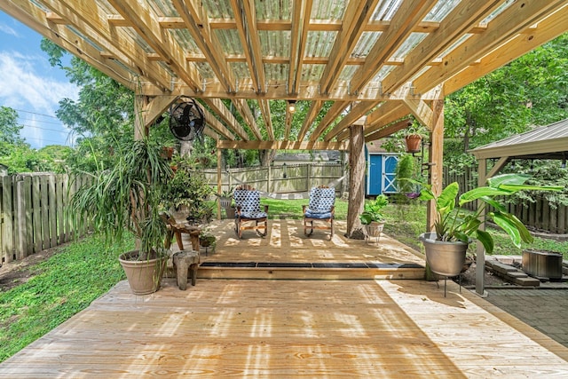 view of patio / terrace featuring a wooden deck and a storage shed