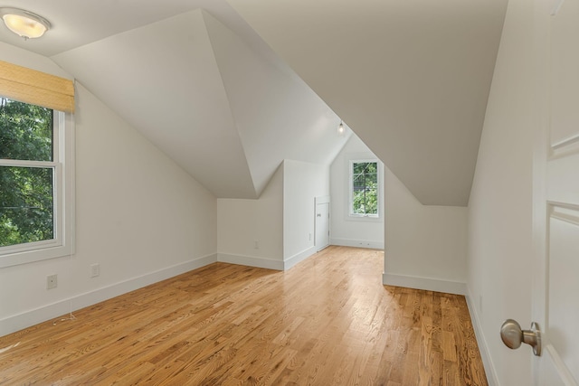 additional living space featuring light hardwood / wood-style floors and vaulted ceiling