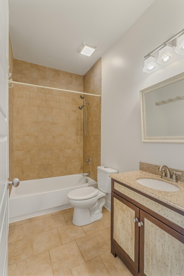 full bathroom with vanity, tile patterned flooring, tiled shower / bath, and toilet