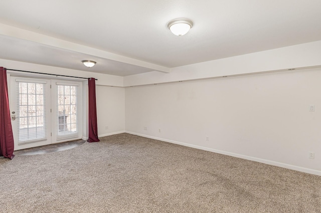 carpeted empty room featuring beam ceiling