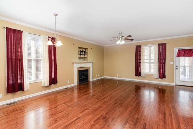 unfurnished living room with crown molding, a healthy amount of sunlight, hardwood / wood-style floors, and a fireplace