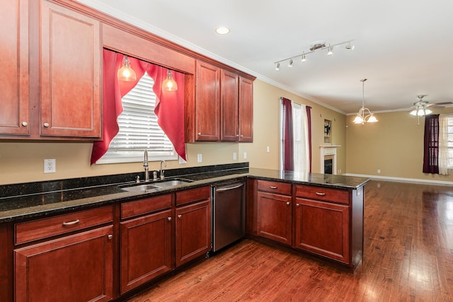 kitchen featuring sink, crown molding, dark stone countertops, dishwasher, and kitchen peninsula