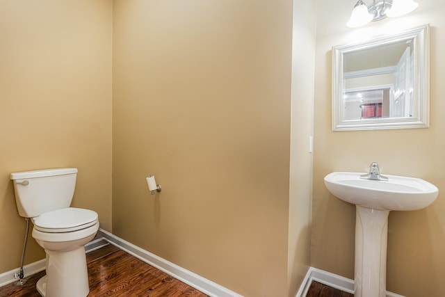 bathroom with hardwood / wood-style flooring and toilet