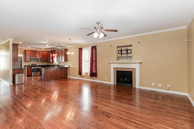 unfurnished living room with ornamental molding, dark wood-type flooring, ceiling fan, and a fireplace