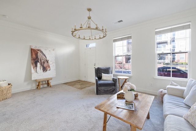 living room with carpet flooring, crown molding, and an inviting chandelier