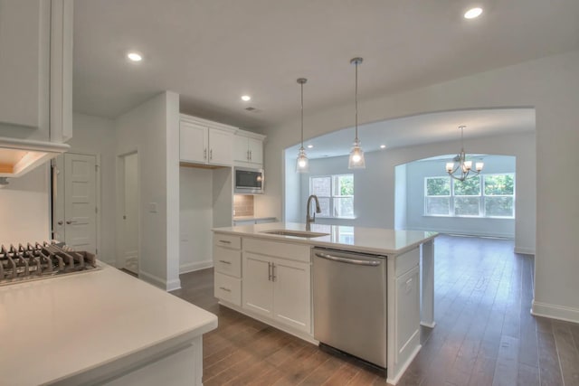 kitchen featuring pendant lighting, white cabinetry, sink, a kitchen island with sink, and stainless steel appliances