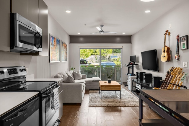 living room with ceiling fan and dark wood-type flooring