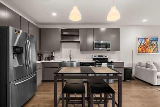 kitchen with decorative light fixtures, gray cabinets, sink, and appliances with stainless steel finishes