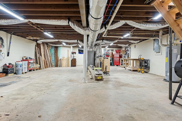 basement featuring electric panel and water heater