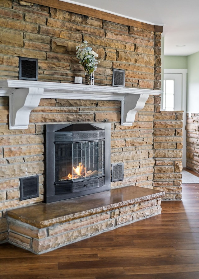 details featuring hardwood / wood-style flooring and a stone fireplace