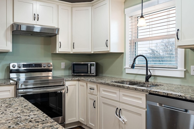 kitchen featuring sink, light stone countertops, appliances with stainless steel finishes, white cabinetry, and extractor fan