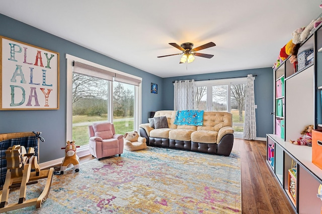 living room featuring ceiling fan and dark hardwood / wood-style flooring