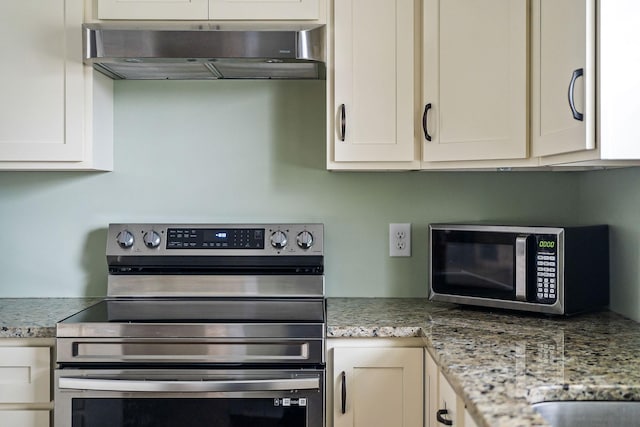 kitchen featuring light stone countertops, range hood, and appliances with stainless steel finishes