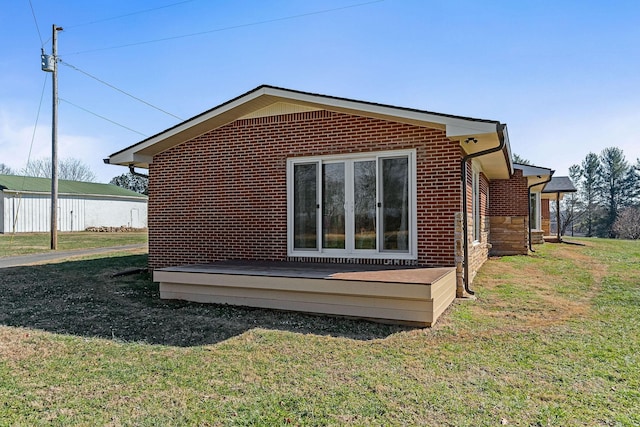 view of home's exterior with a wooden deck and a yard