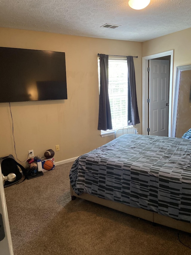 carpeted bedroom with a textured ceiling