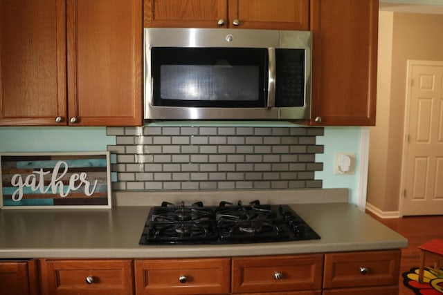 kitchen featuring backsplash and black gas stovetop