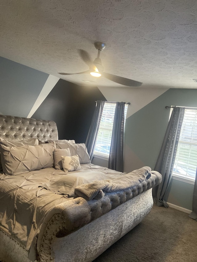 carpeted bedroom featuring vaulted ceiling, ceiling fan, and a textured ceiling