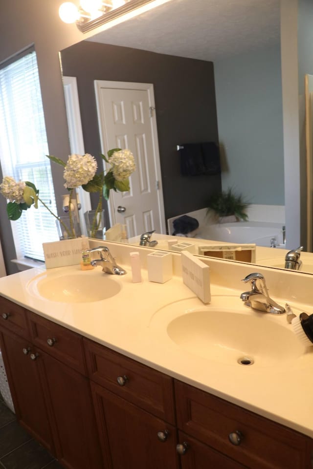 bathroom featuring tile patterned floors, vanity, and a tub