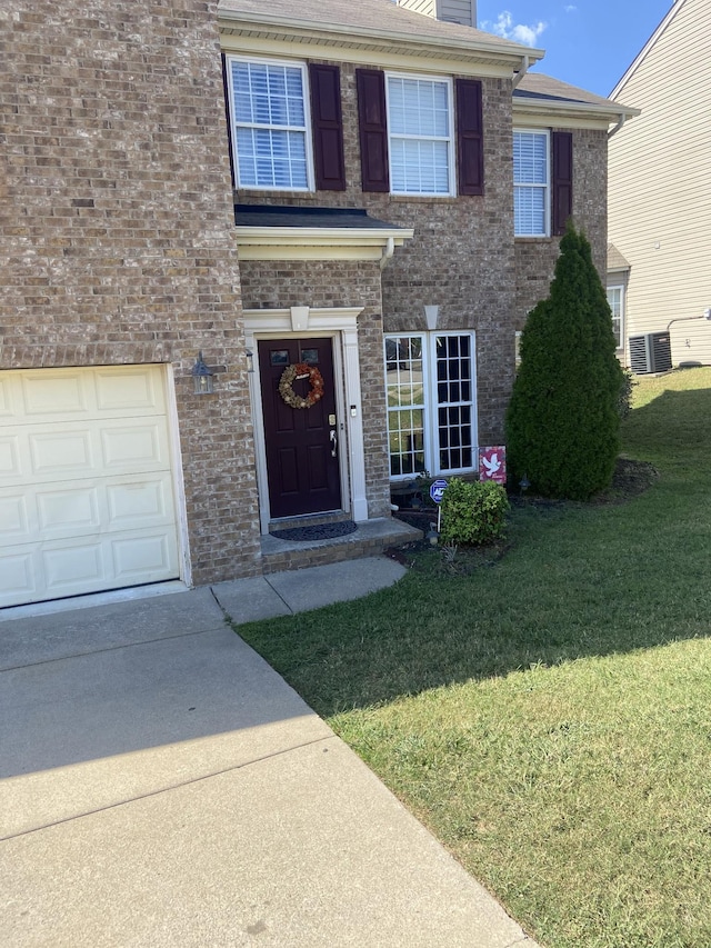 view of front of home with central air condition unit and a front yard