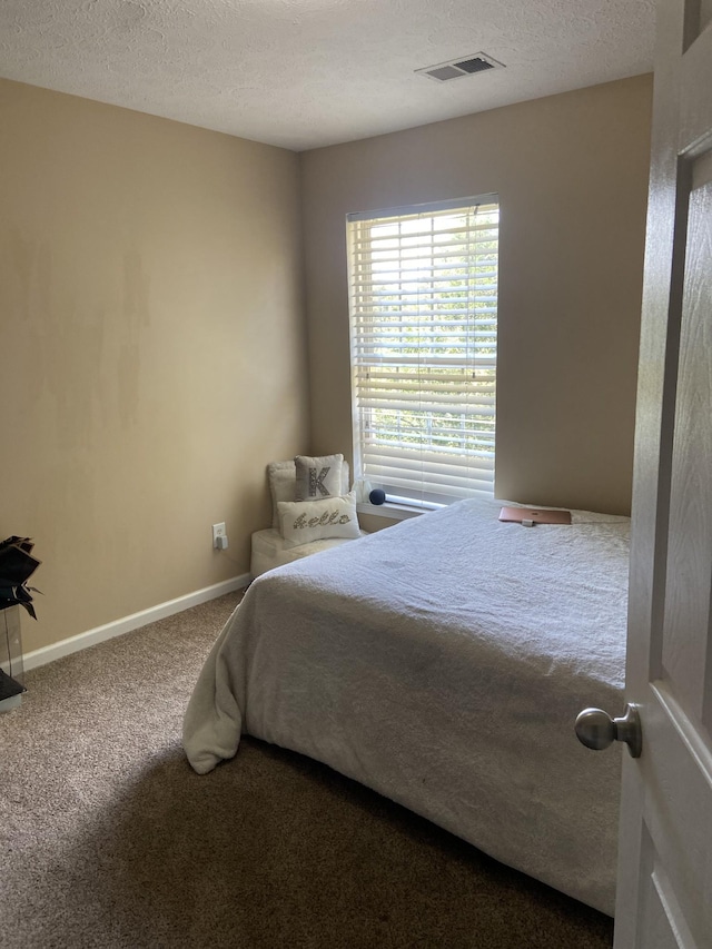 bedroom with carpet floors and a textured ceiling