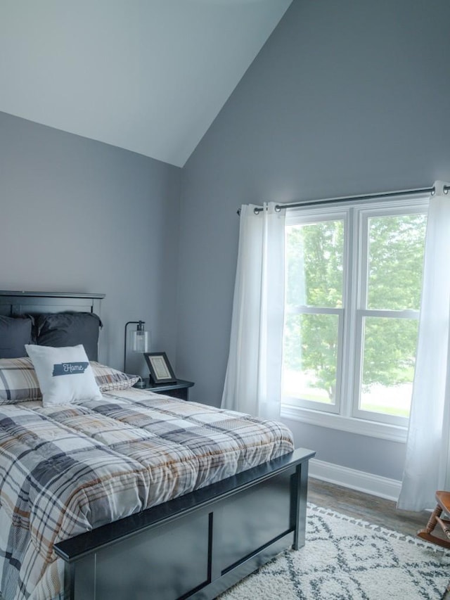 bedroom featuring light hardwood / wood-style flooring and lofted ceiling